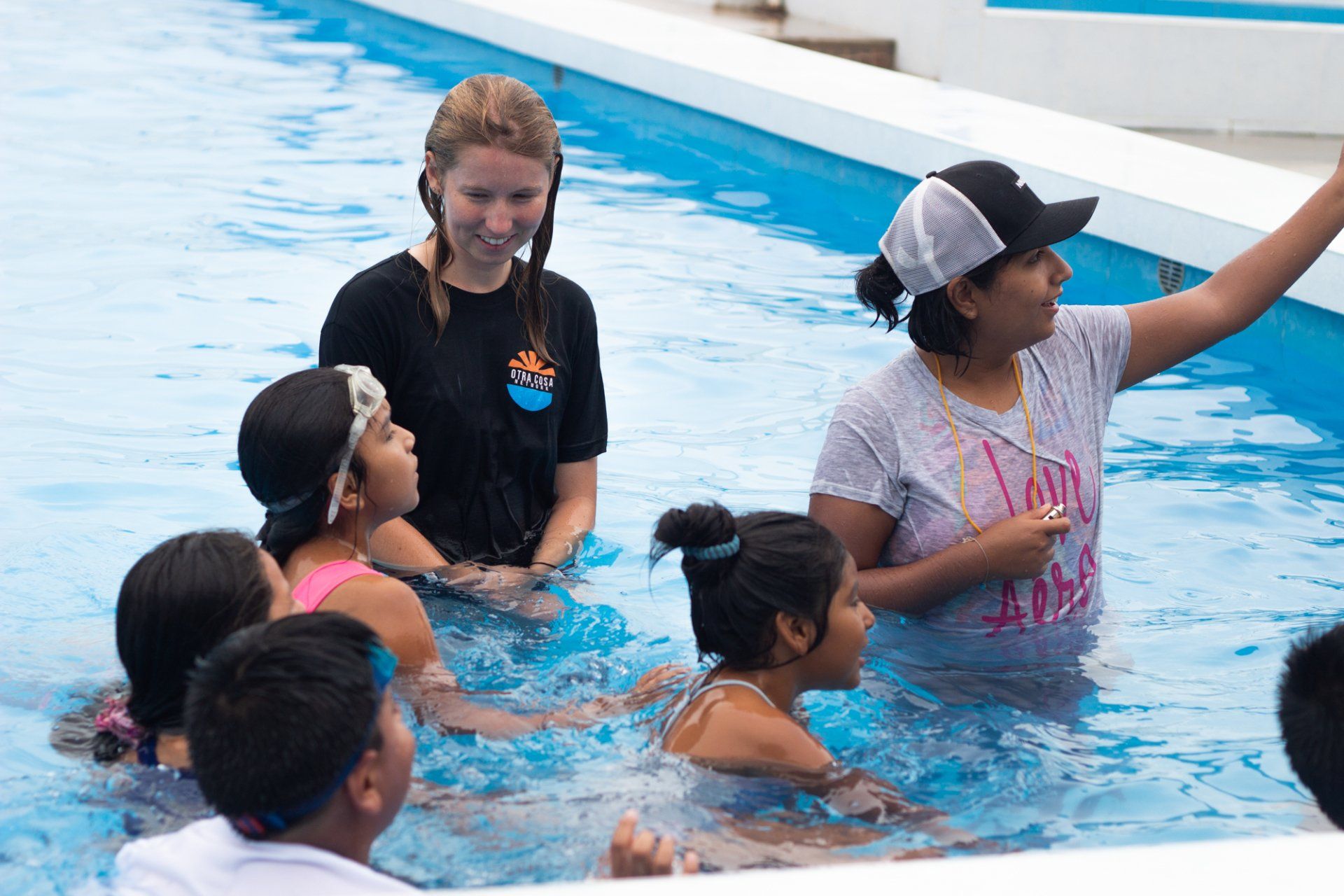 A picture of an Otra Cosa volunteer giving swimming lessons to children in Huanchaco, Peru.