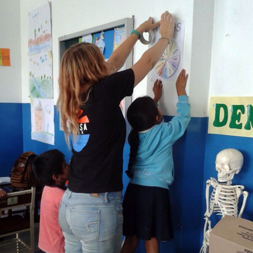 Otra Cosa volunteers delivering an English lesson in a classroom.