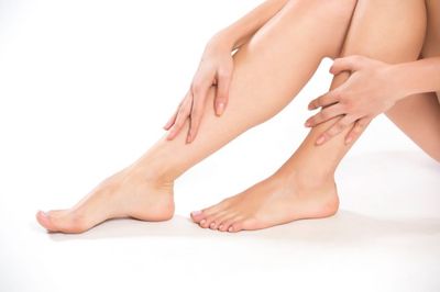 Woman holding her legs — Diabetic feet in Westborough, MA Woman holding her legs — Diabetic feet in Westborough, MA