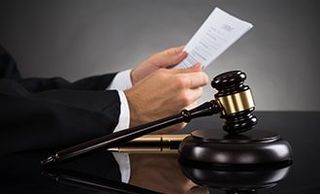 Judge Holding Document At Desk - attorneys in Salem, MA