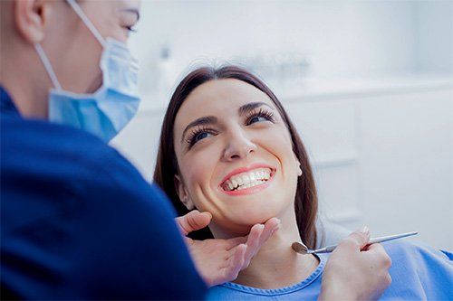 Dentist examining a smiling patient in a dental office