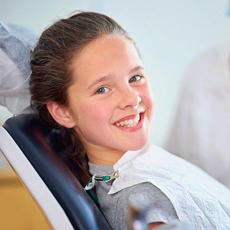 Smiling patient reclining in a dental chair during a checkup