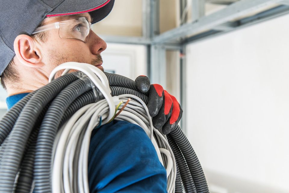 Electrician Holding Cables and Pipes — Mobile, AL — Presley & Son Electric Service