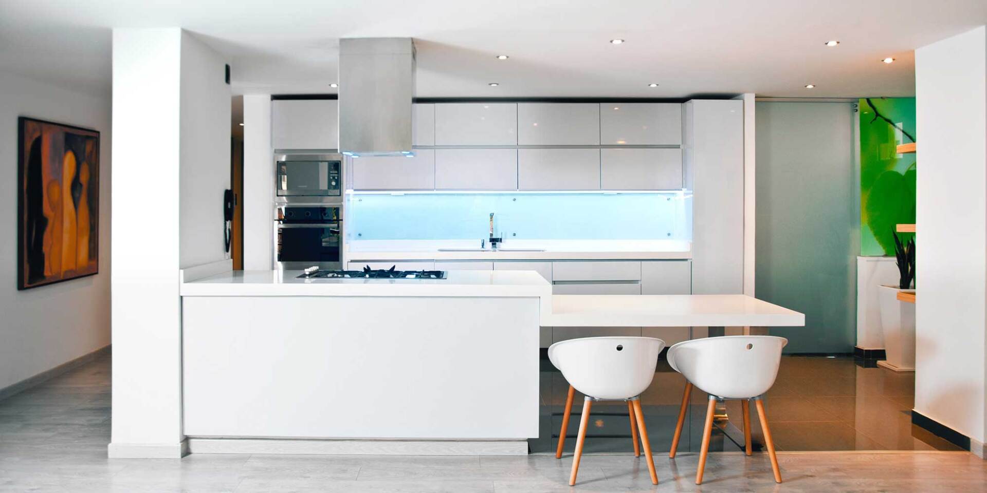 Slimline white kitchen with a blue glass backsplash Slimline white kitchen with a blue glass backsplash