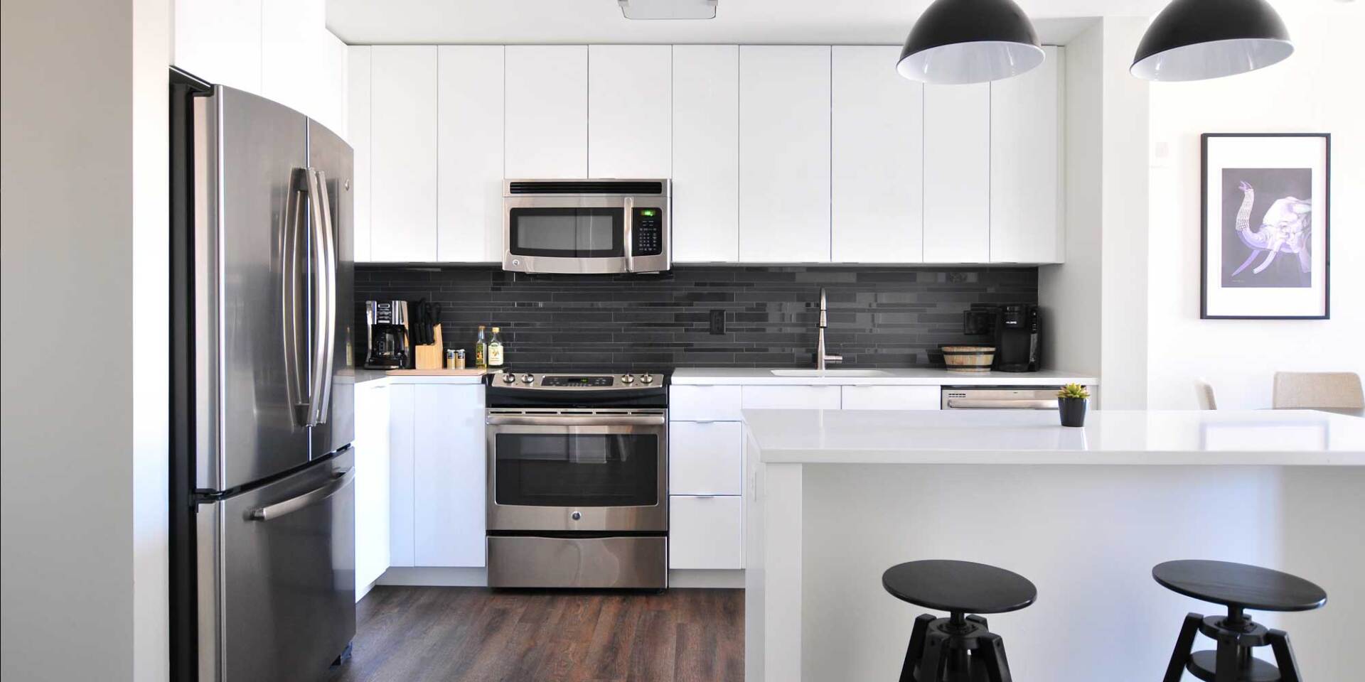 Dark gray backsplash using the same grout color as the tiles White kitchen with dark gray tile backsplash