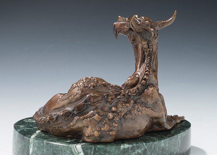 sculpture of resting dragon in bronze