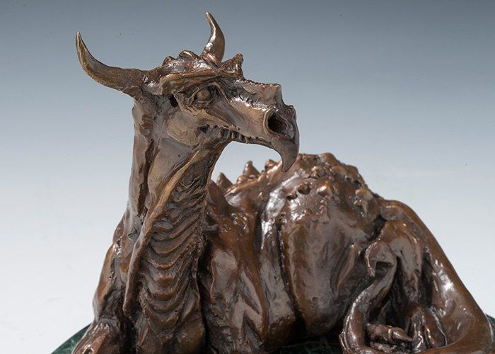 sculpture of resting dragon in bronze close up