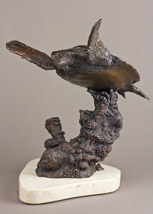 green sea turtle sculpture on stone base