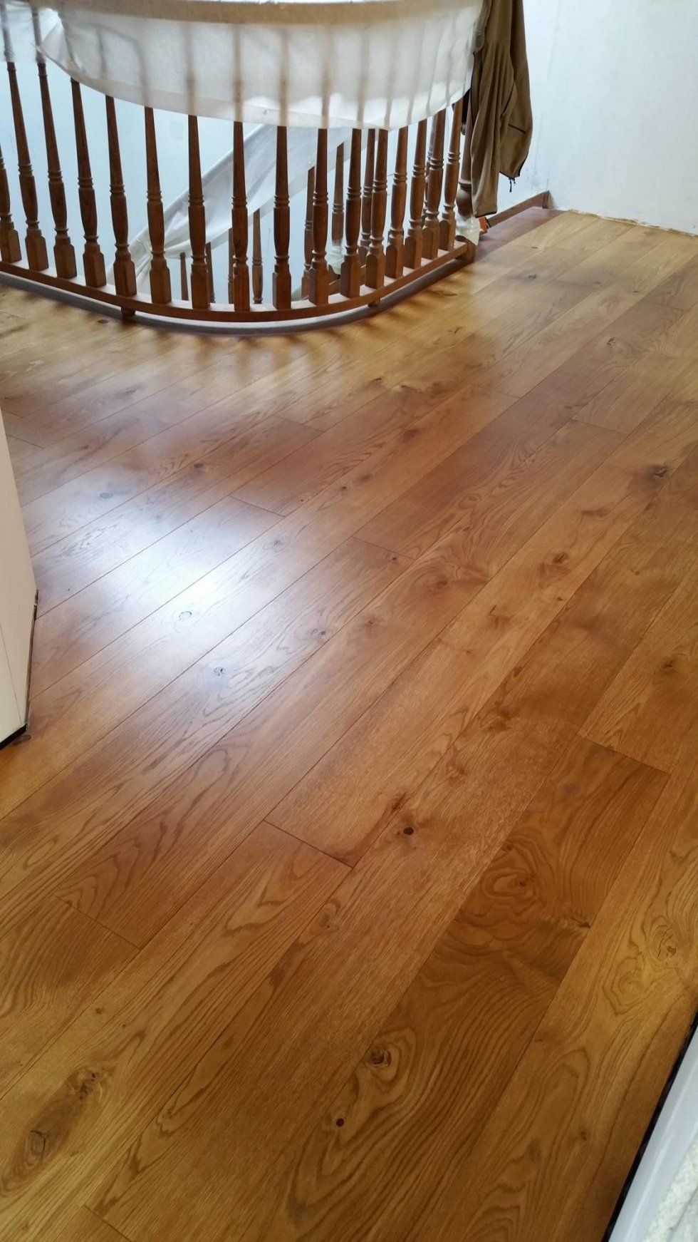 Pavimento in legno con una scala curva sullo sfondo.