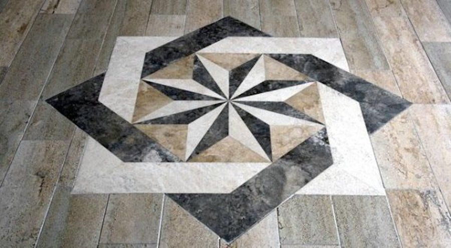 Motivo di piastrelle per pavimenti con motivo a stella nei colori grigio, beige e bianco.