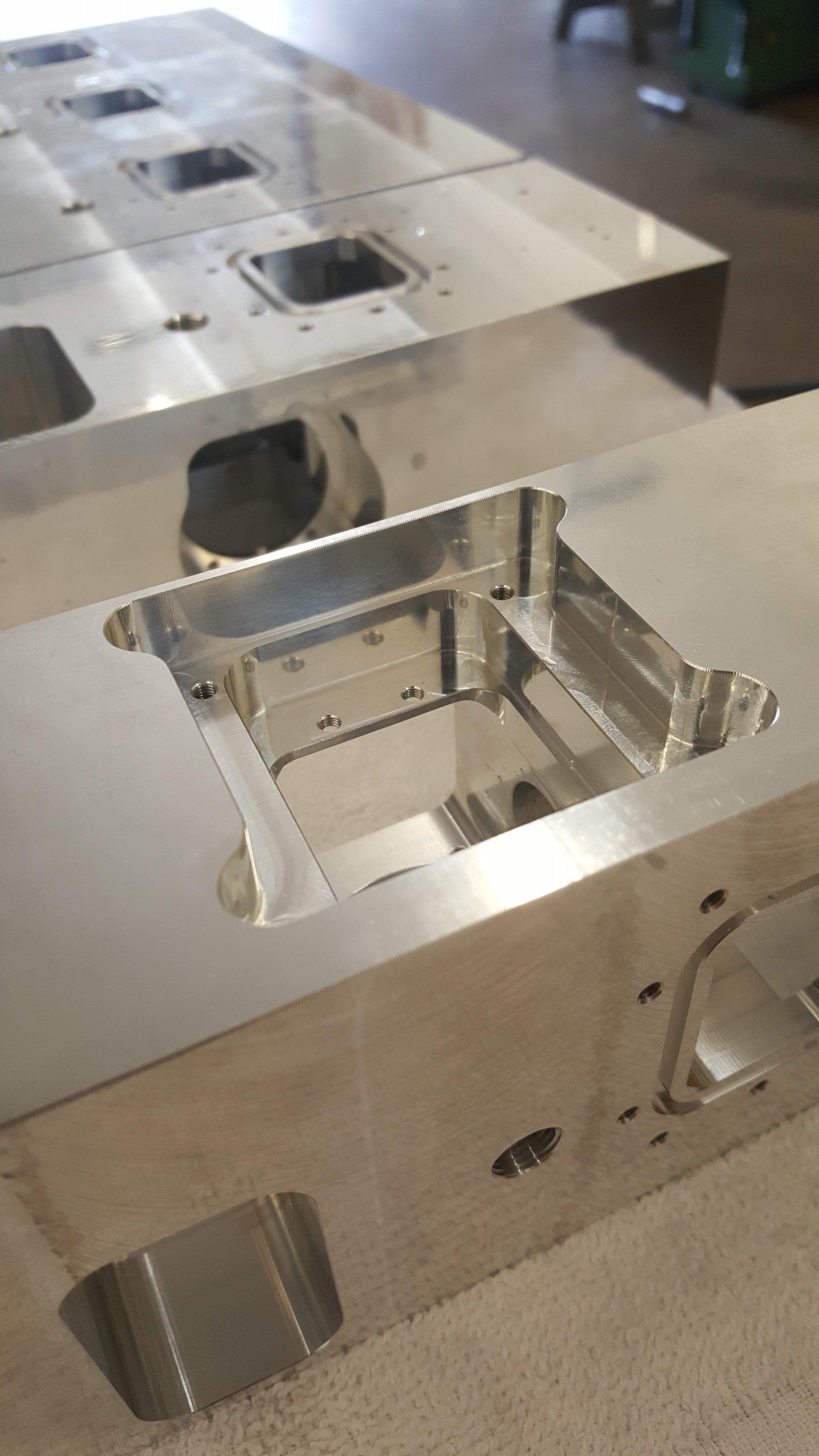 A row of stainless steel pieces sitting on top of each other on a table.