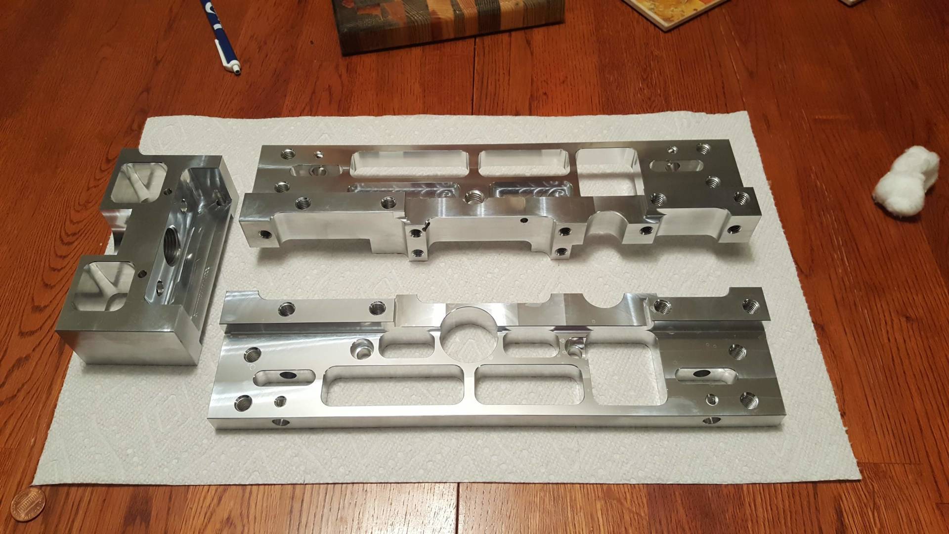 Three pieces of metal are sitting on a towel on a wooden table.