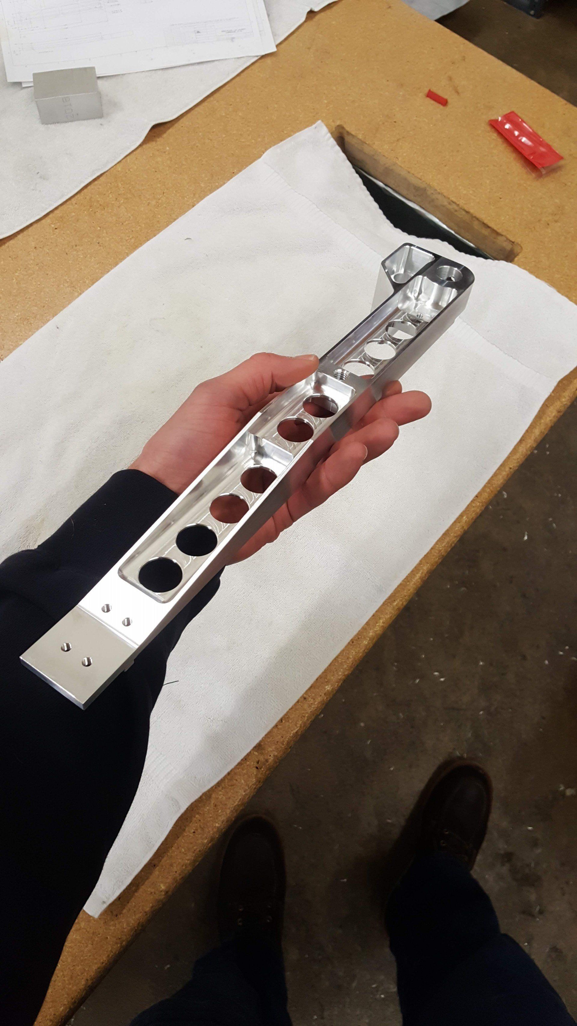 A person is holding a piece of metal in their hand.