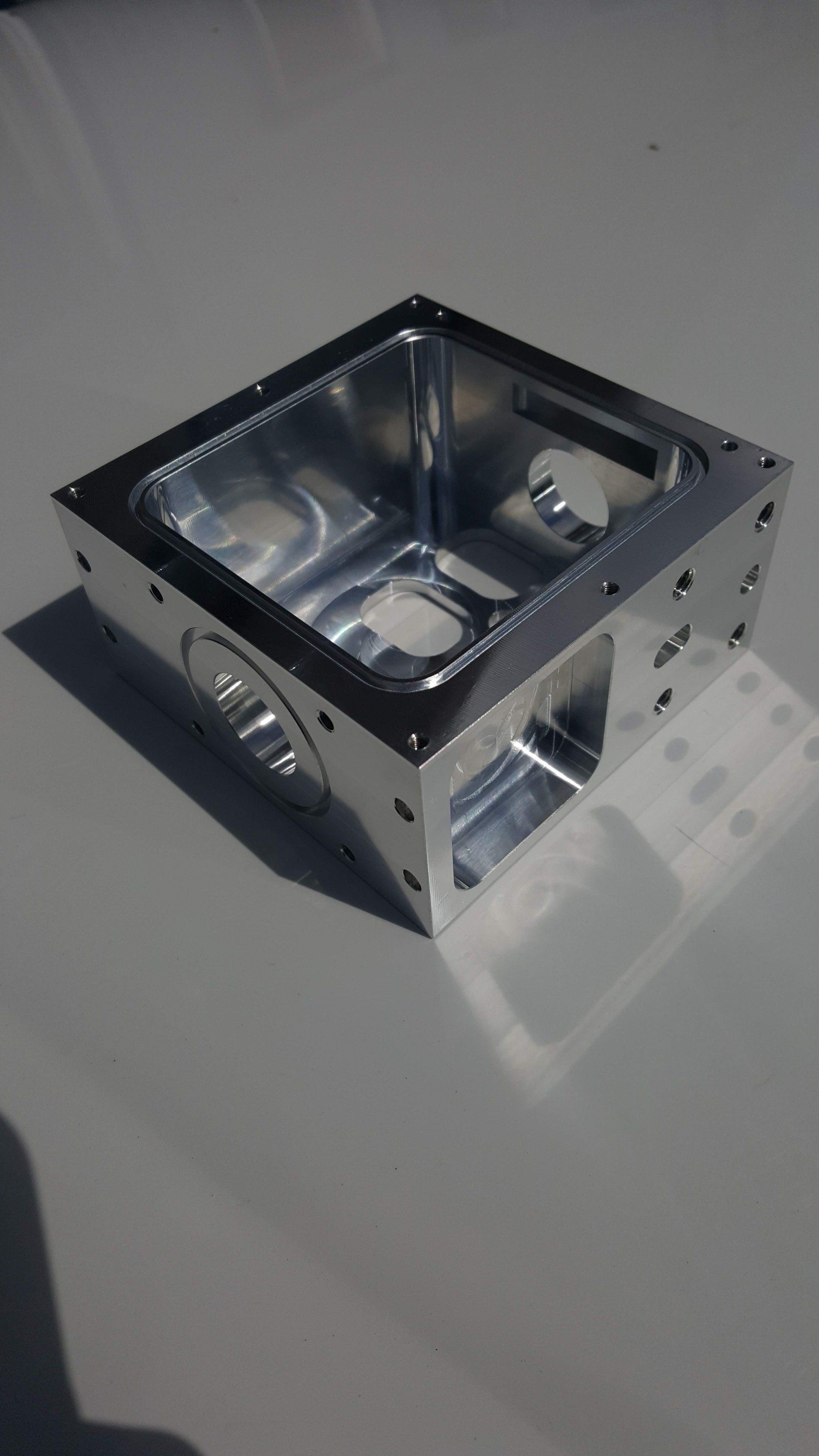 A metal box is sitting on top of a gray surface.