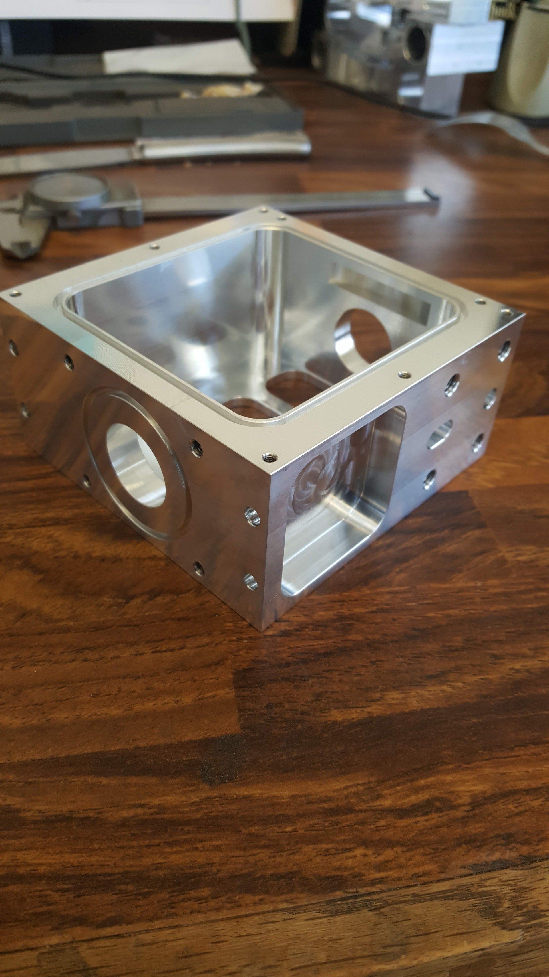 A metal box is sitting on top of a wooden table.