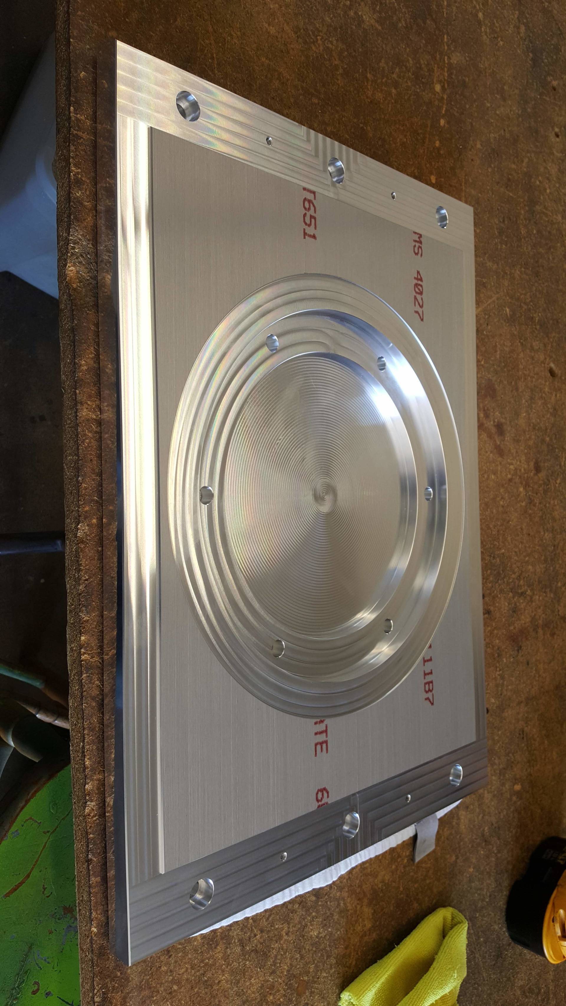 A metal plate is sitting on top of a wooden table.