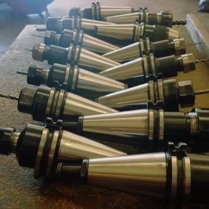A bunch of drill bits are lined up on a table