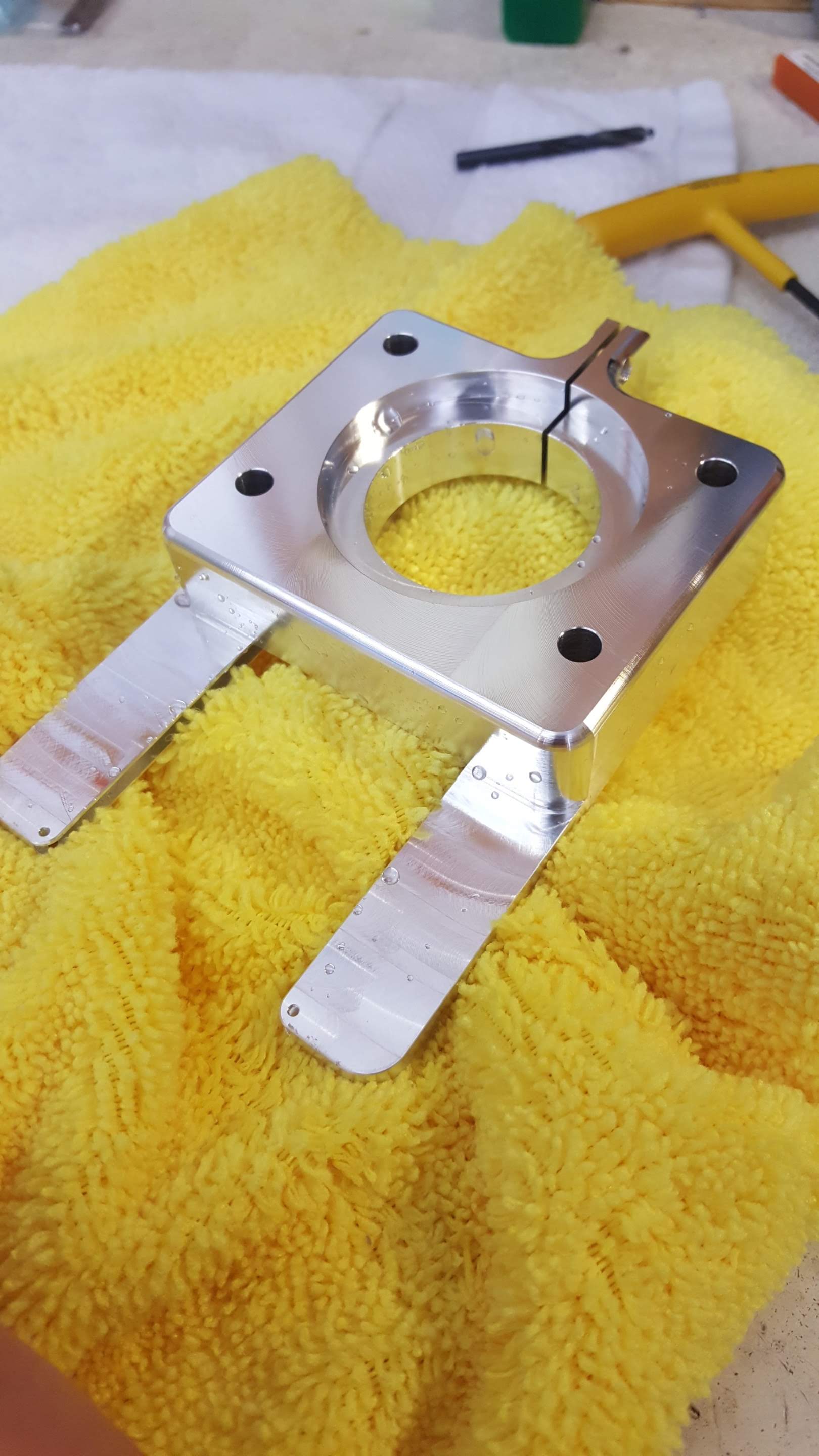 A metal object is sitting on top of a yellow towel.