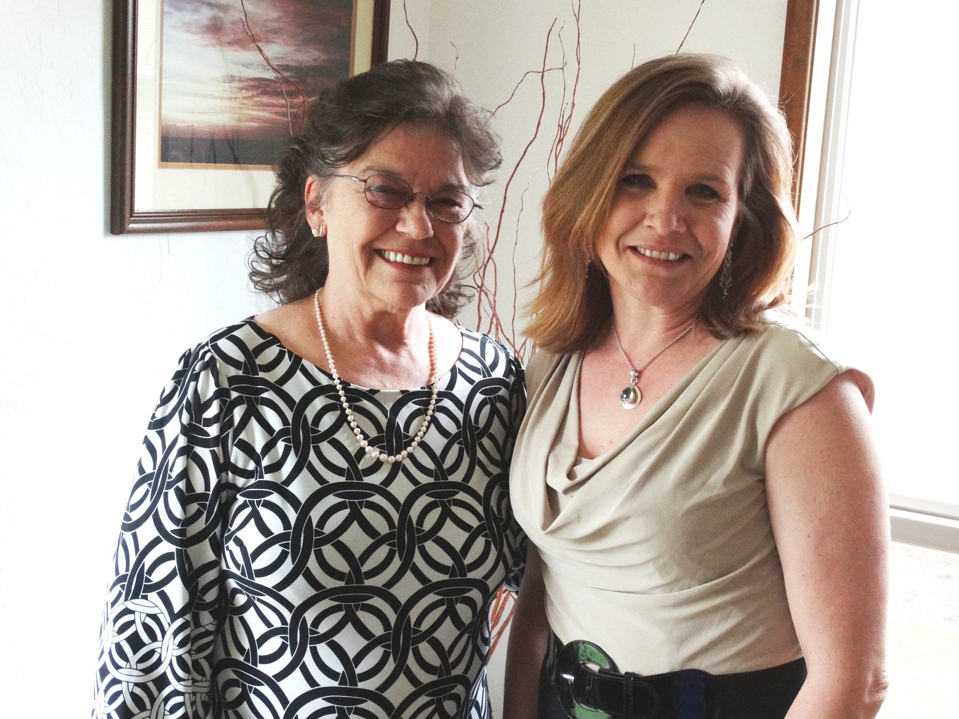 Two women are posing for a picture and smiling for the camera
