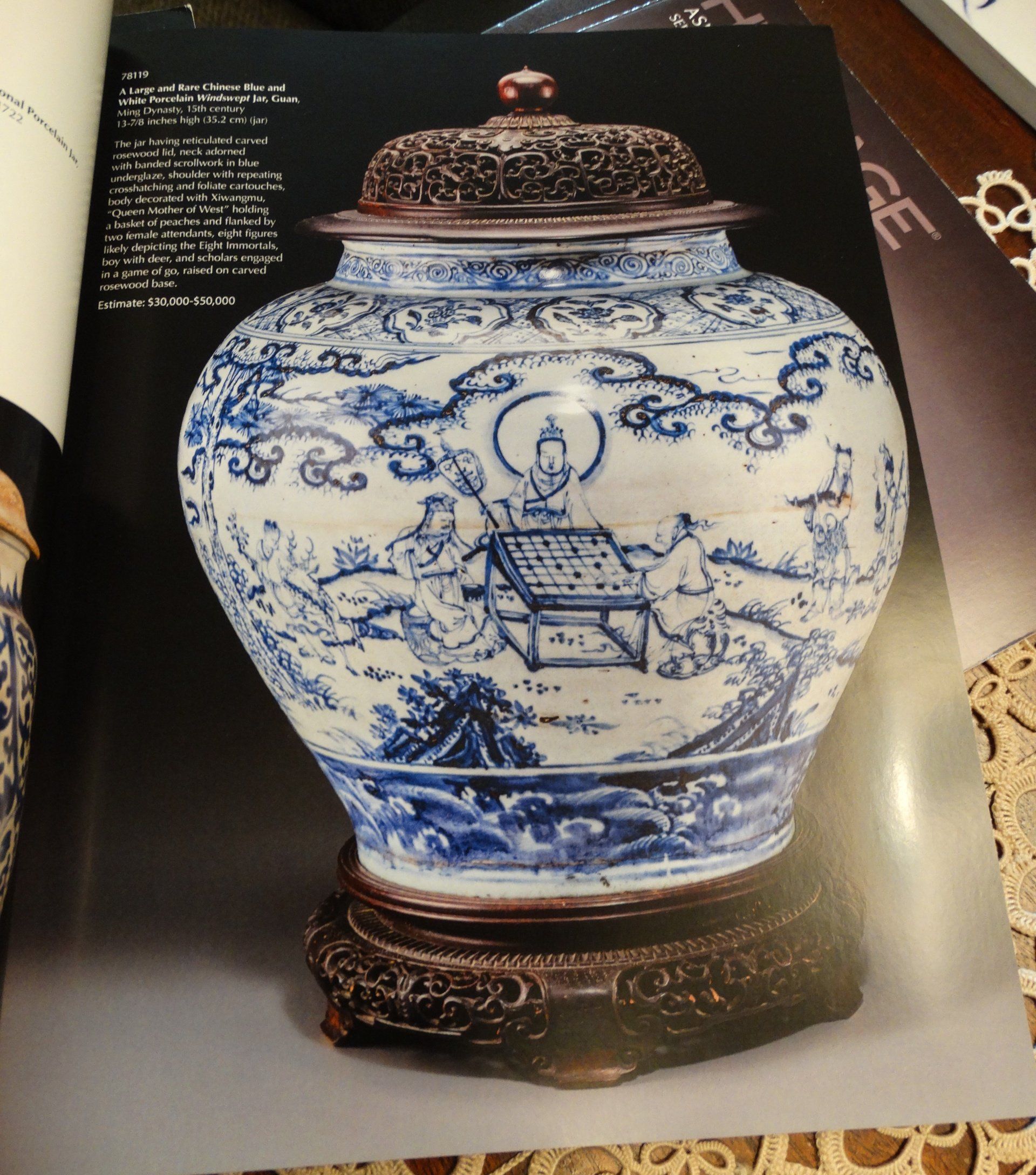 A blue and white vase with a lid sits on a table