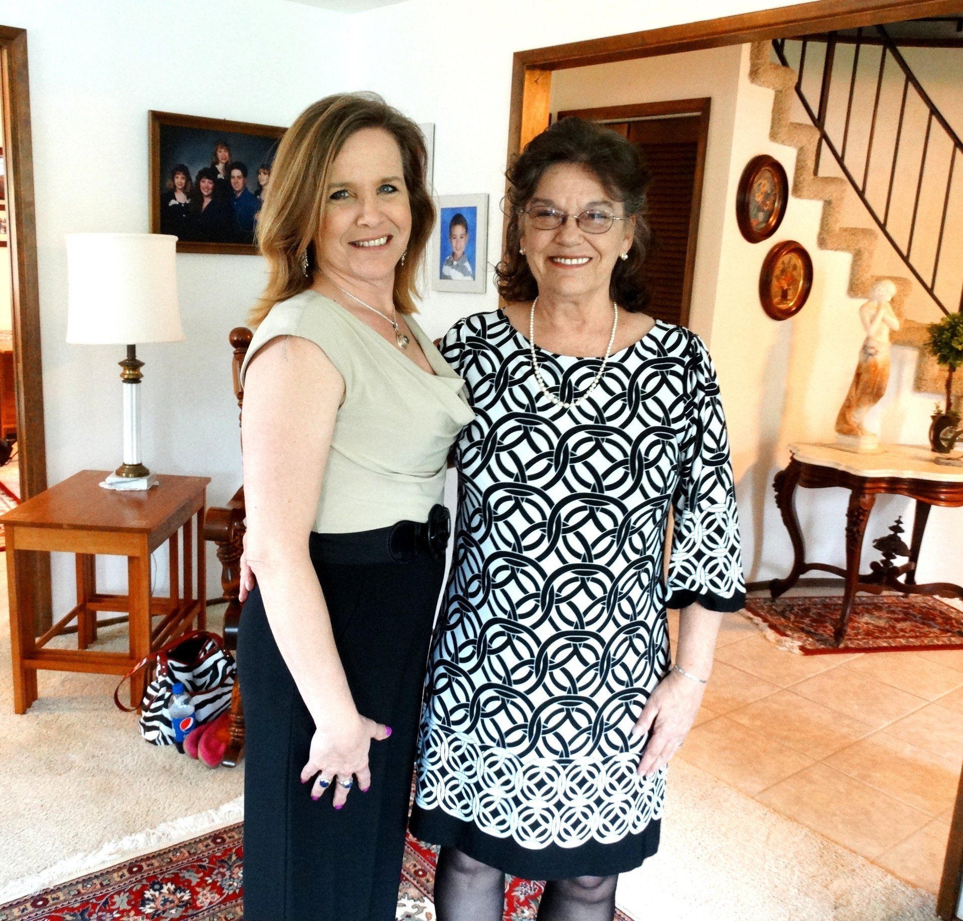 Two women are posing for a picture in a living room