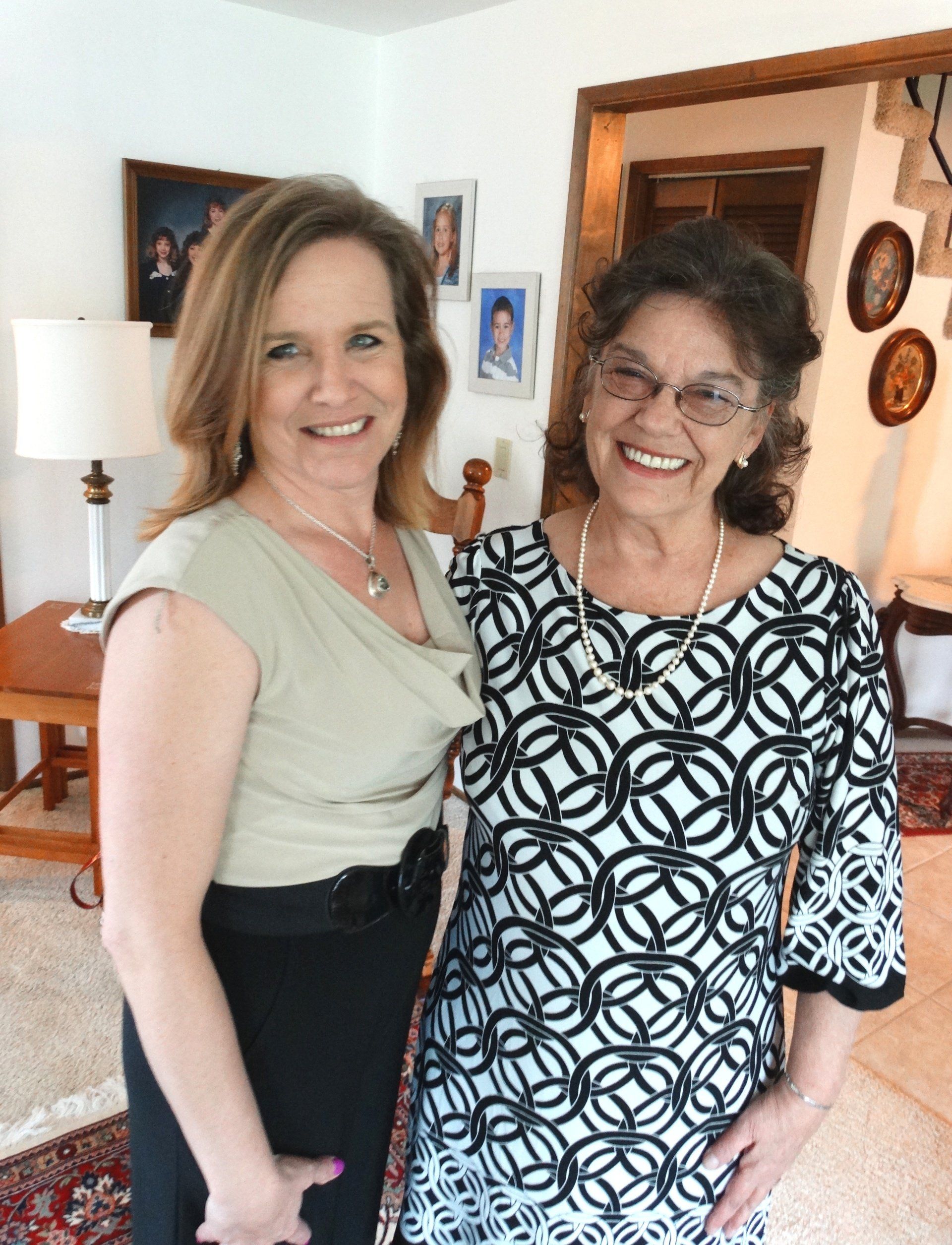 Two women are posing for a picture in a living room