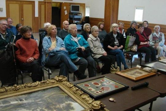 Appraisals — How Much Is Your Property Worth Sign in Eugene, OR A group of people are sitting around a table with framed pictures on it