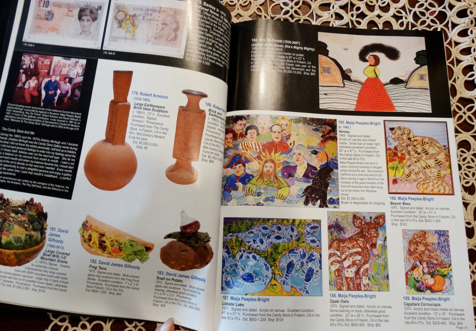 A book is open to a page with pictures of vases and paintings