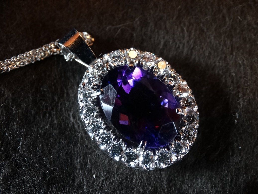 A necklace with a purple stone and diamonds