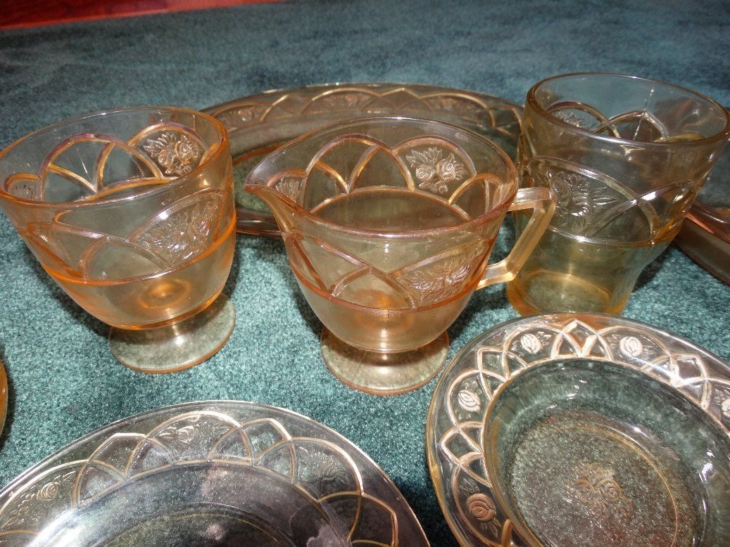 A table topped with plates , glasses , and a pitcher.