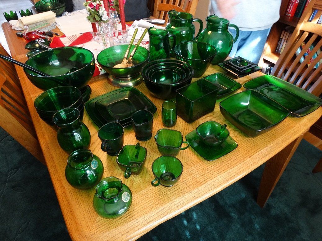 A table topped with lots of green glass dishes