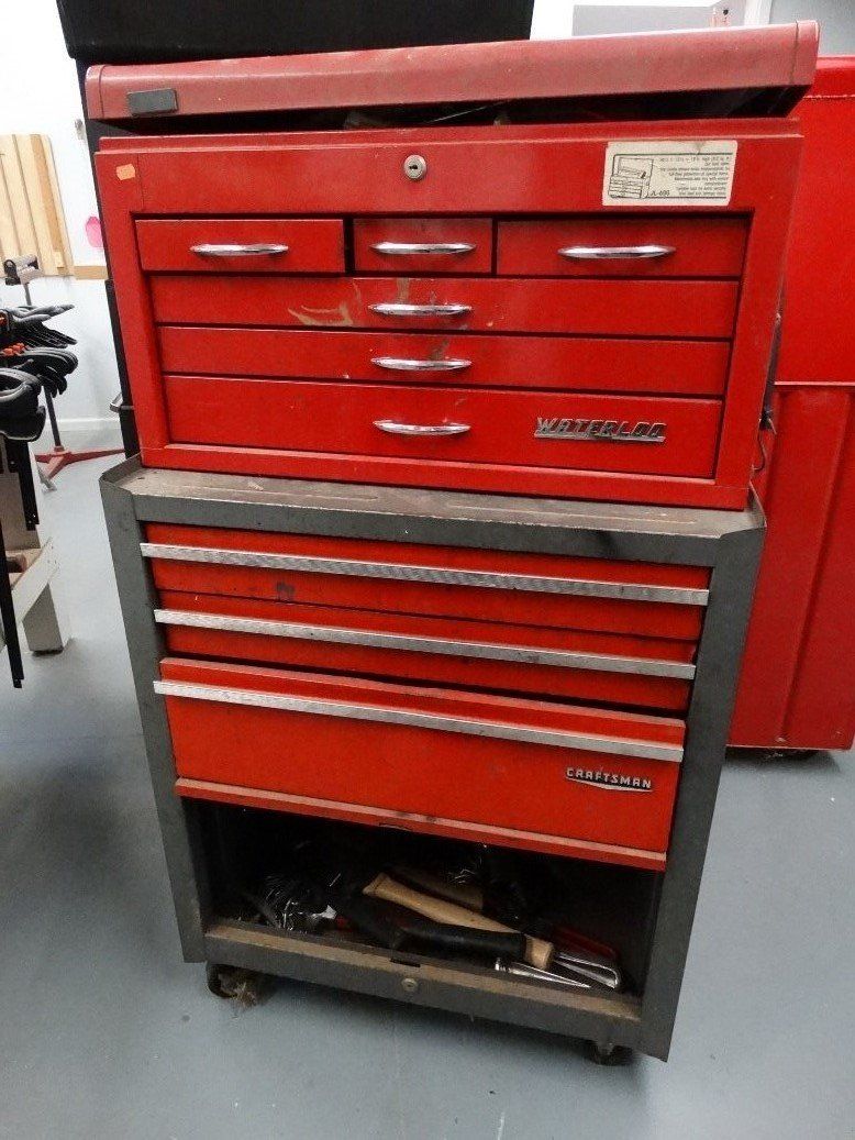 A red toolbox is stacked on top of another red toolbox