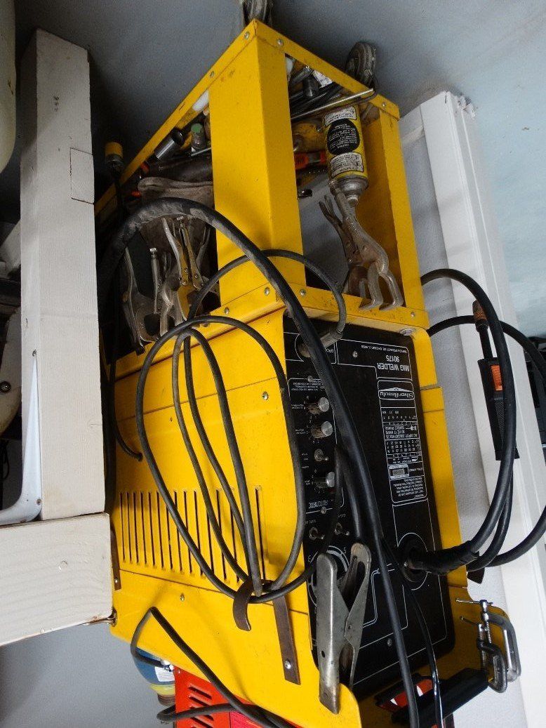 A yellow welding machine is sitting on a table