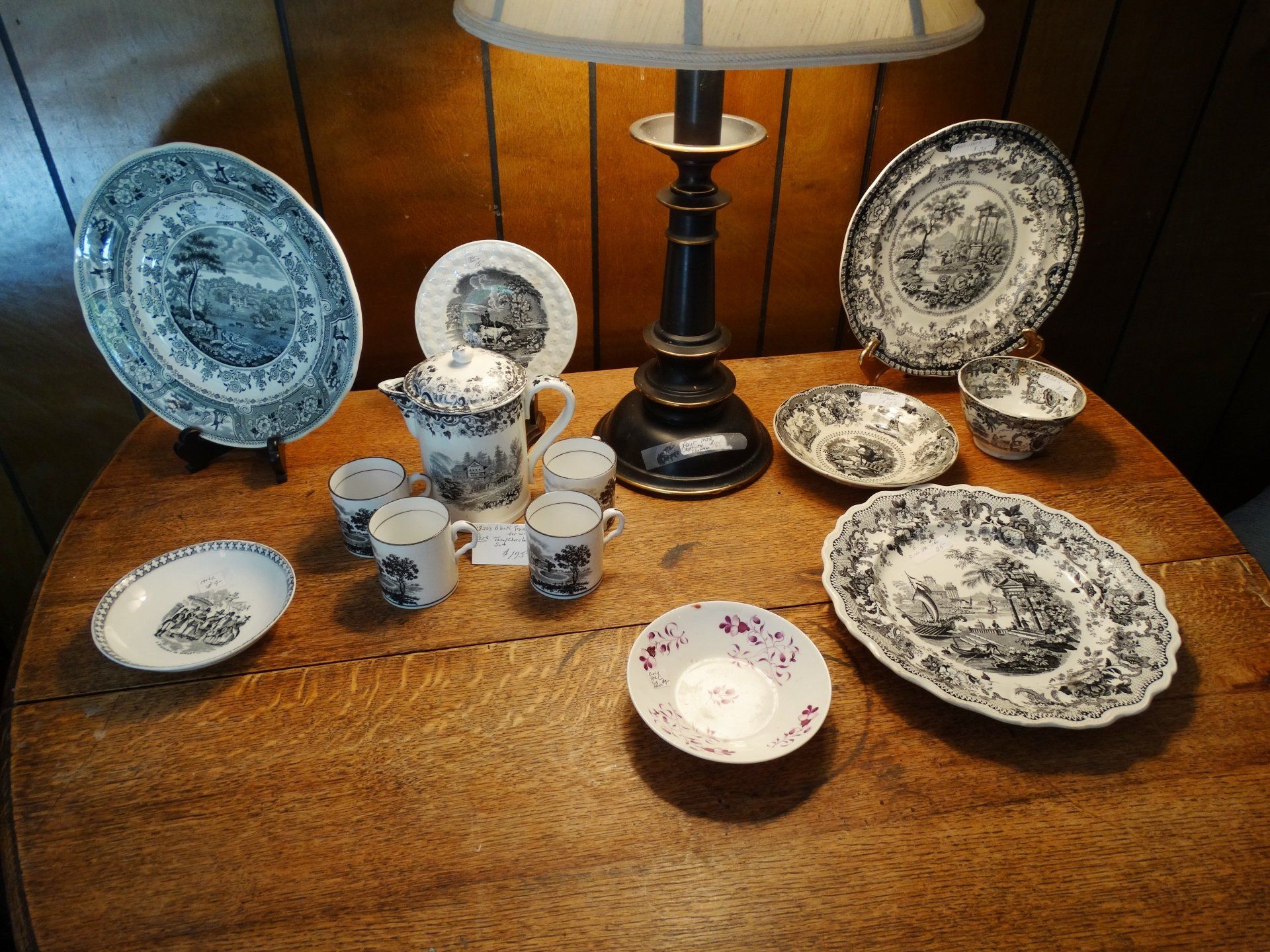 A table with plates cups and a lamp on it