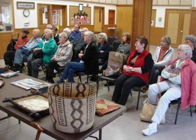 A group of people are sitting around a table with a basket on it