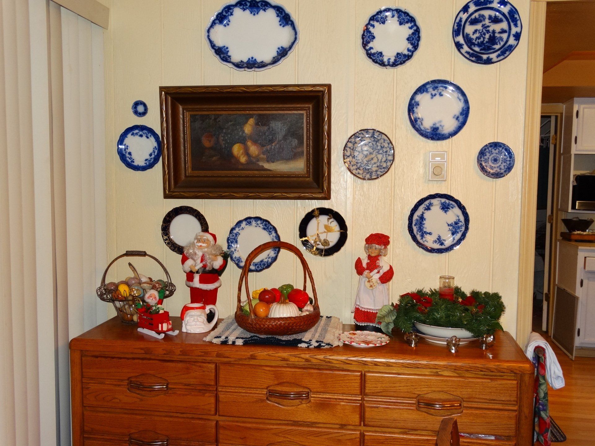A dresser with blue and white plates on the wall above it
