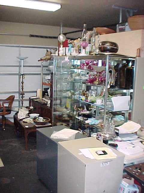 A cluttered room with a lot of items on shelves