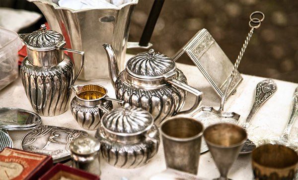 A table topped with a variety of silver objects.