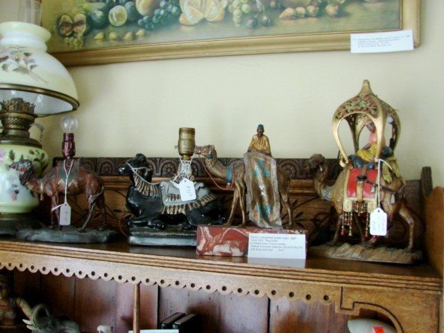 A shelf with a lamp and statues on it