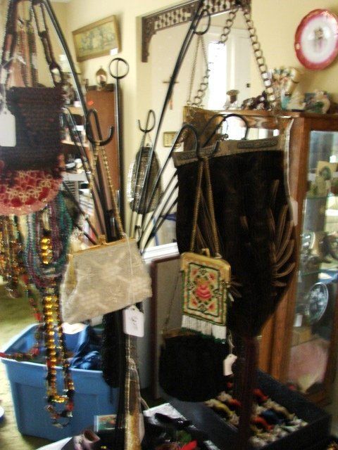 A bunch of handbags are hanging on a rack in a room