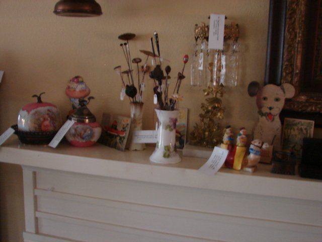 A white dresser with various objects on it including a vase with flowers in it