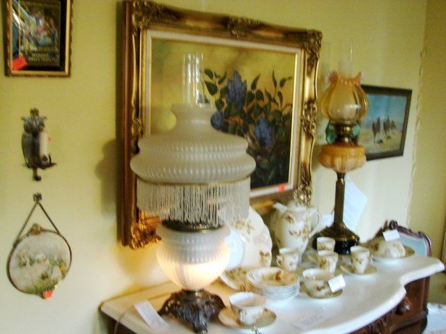 A table with a lamp and a painting on the wall