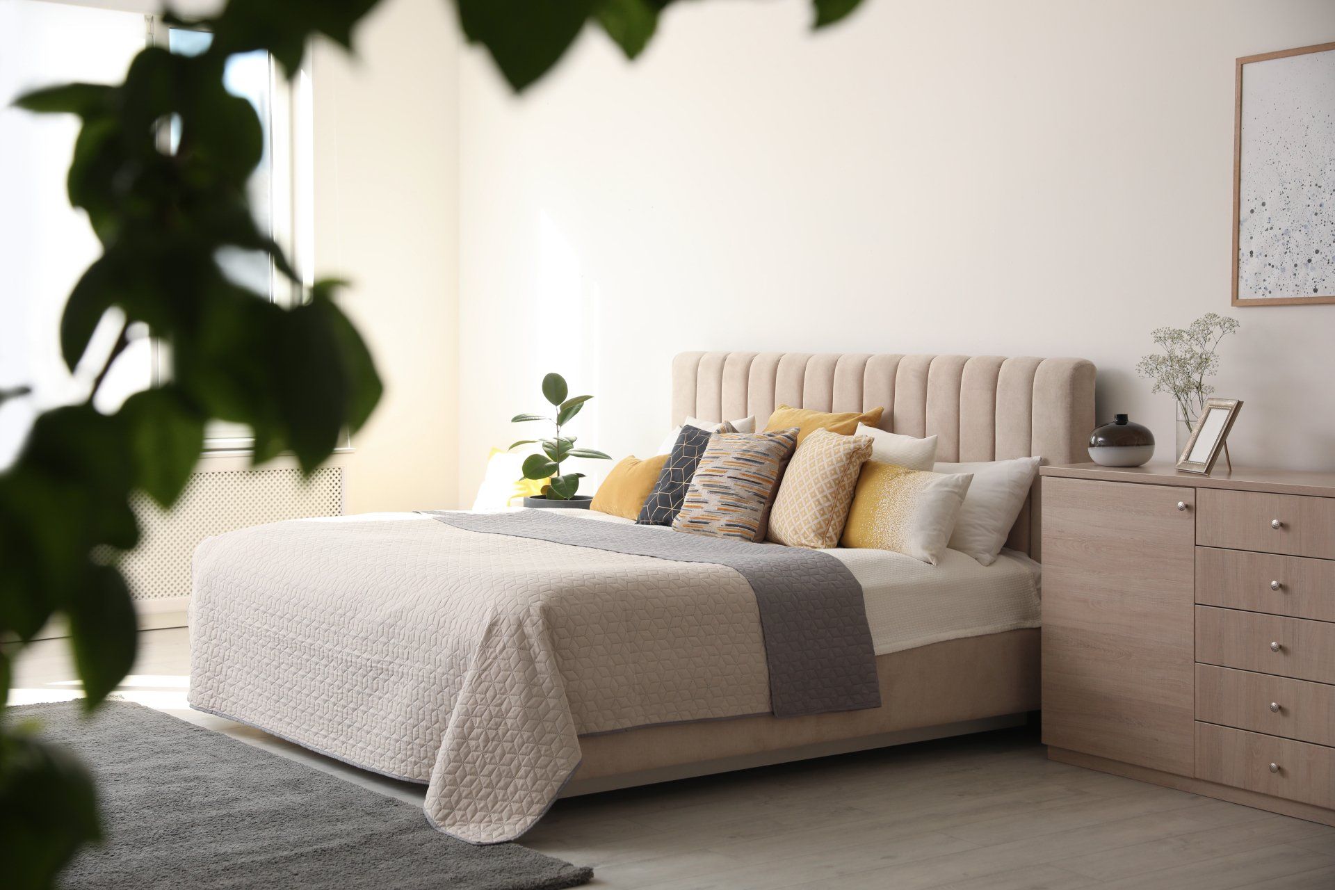 A bedroom with a large bed and a dresser.