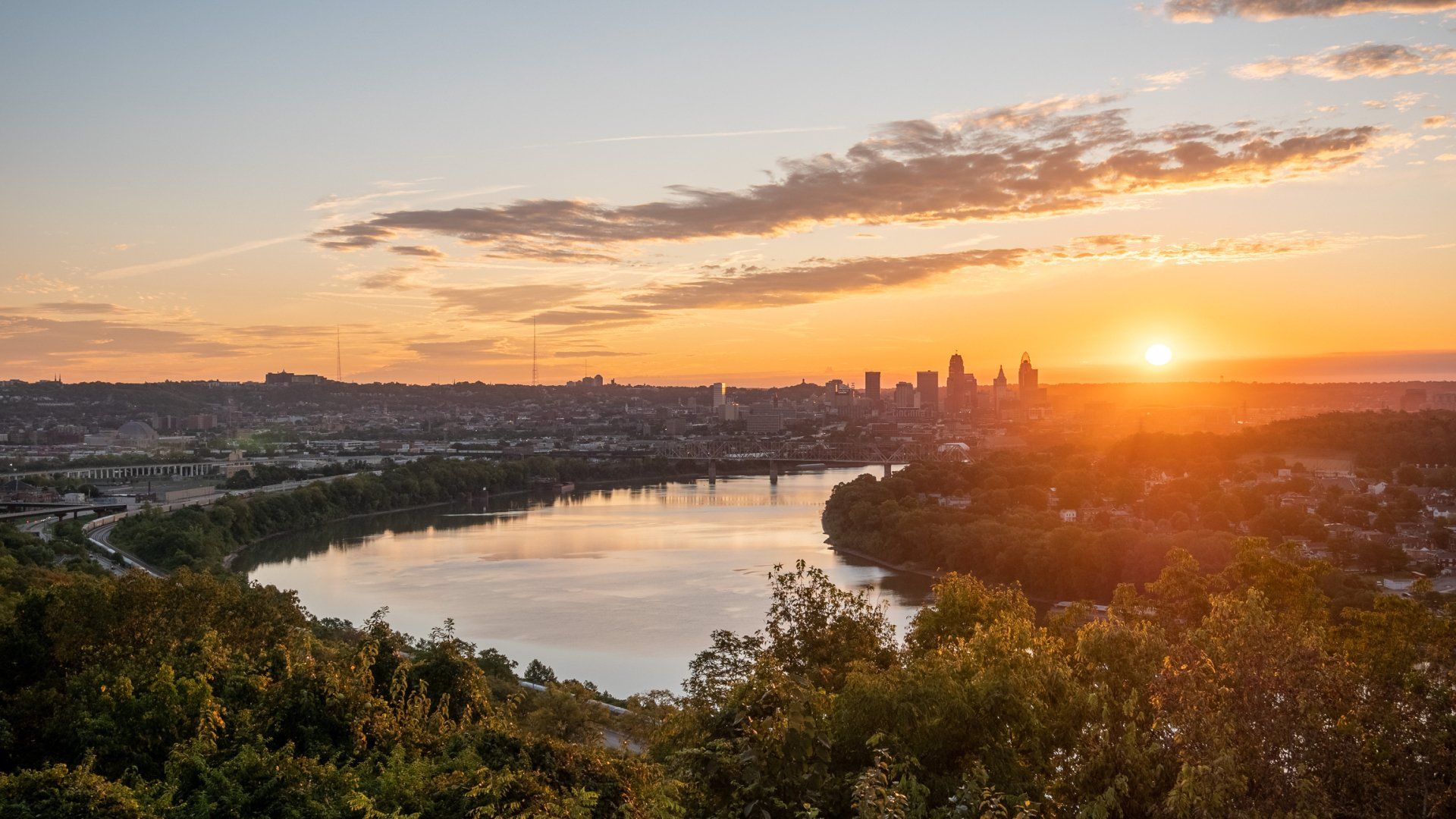 Scenic river view at sunset with city skyline in the distance