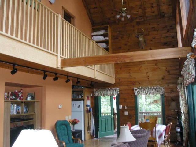 A living room in a log cabin with a balcony