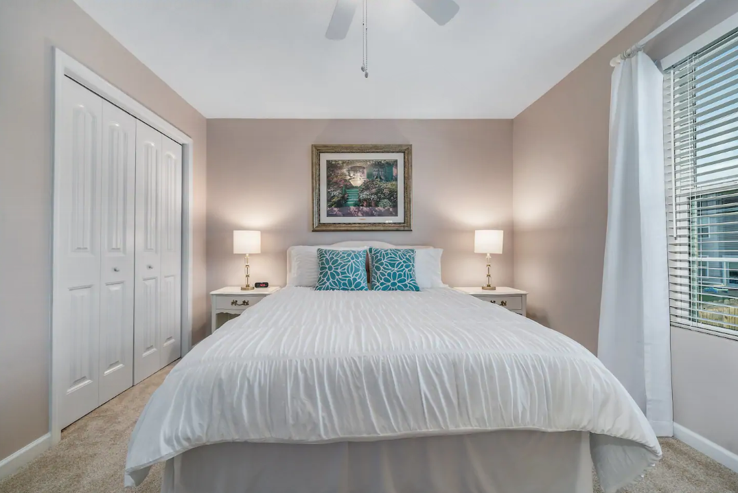 A bedroom with a king size bed and a painting on the wall