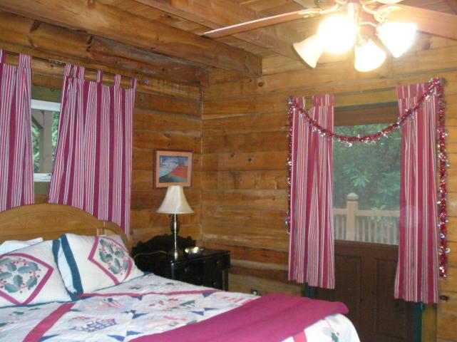 A bedroom with a bed a lamp and a ceiling fan