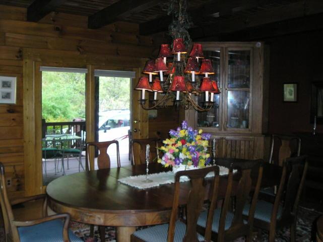 A dining room with a table and chairs and a chandelier