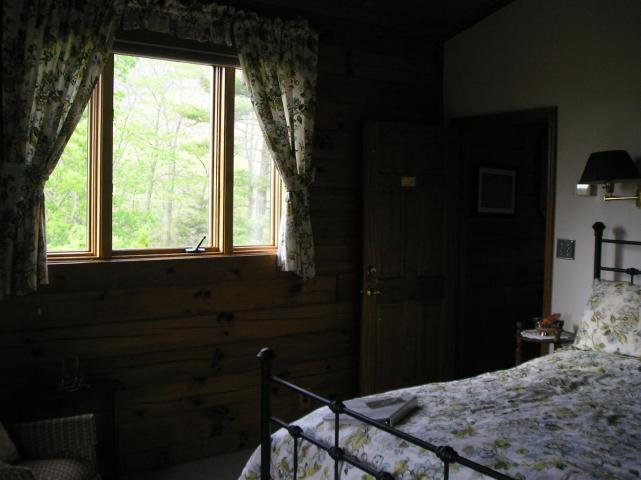 A bedroom with a bed and a large window