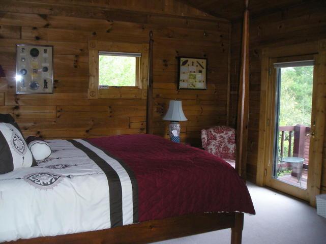 A bedroom with a king size bed and a lamp